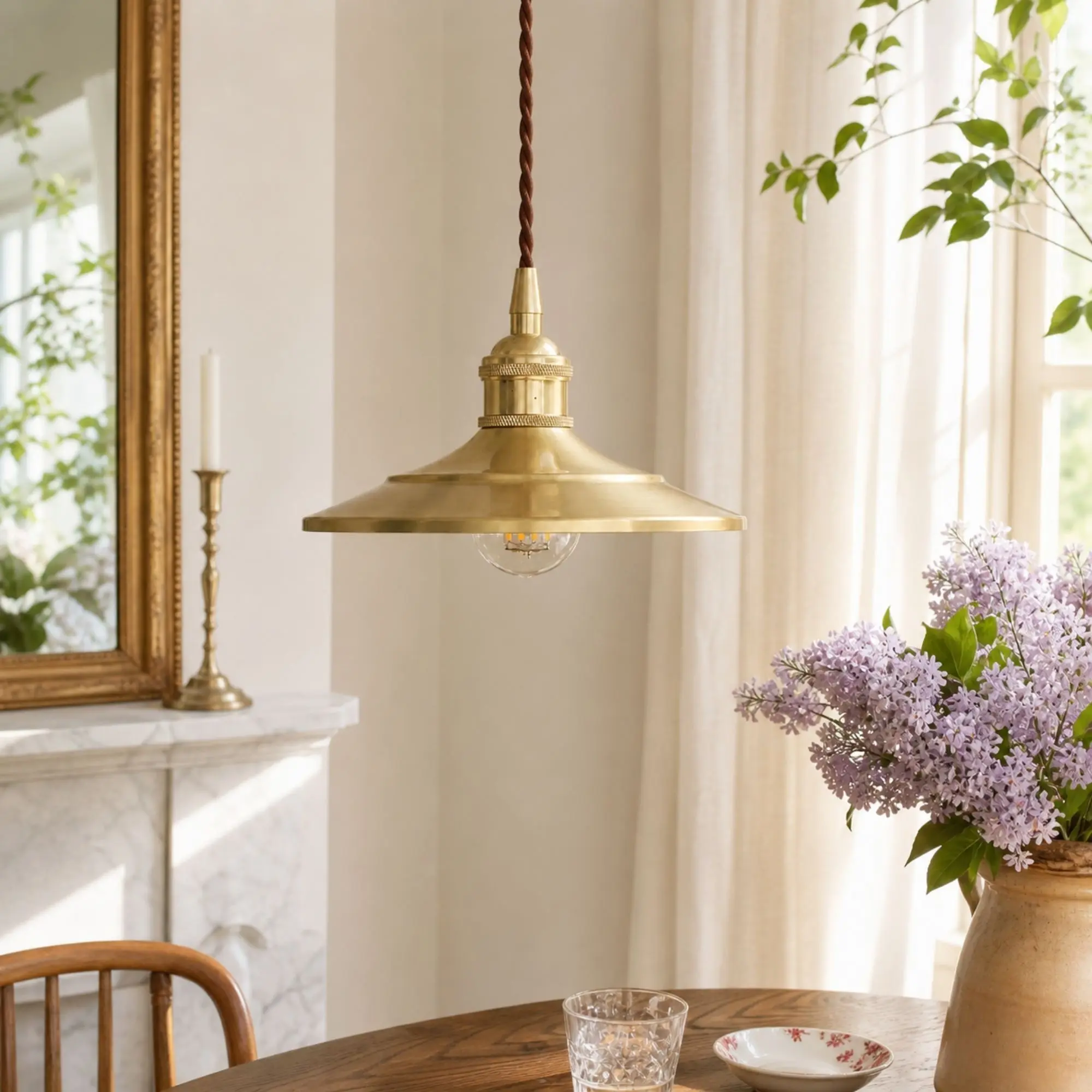 Polished brass pendant light in a bright European-inspired dining room